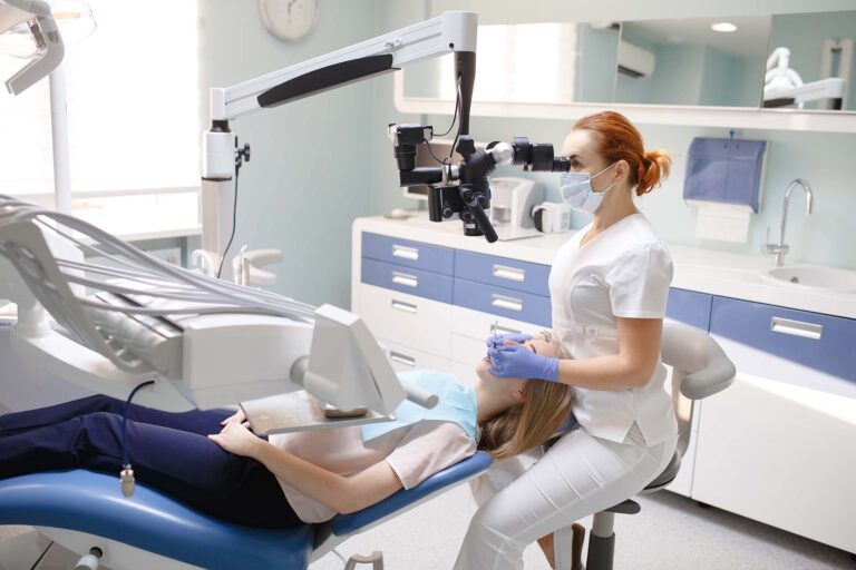 Female dentist with dental tools - microscope, mirror and probe